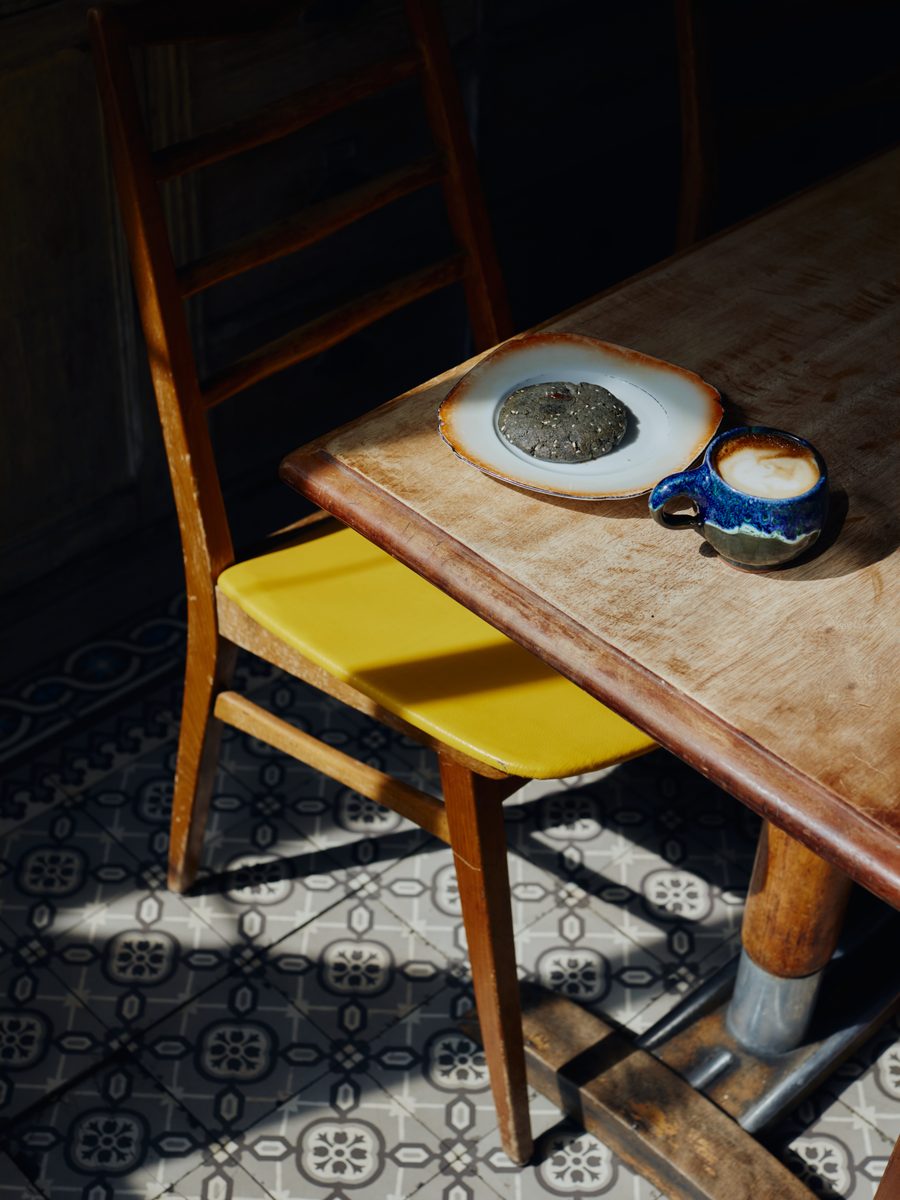 Nature morte ensoleillée : tasse de café et pâtisserie sur une table en bois du café Franquette